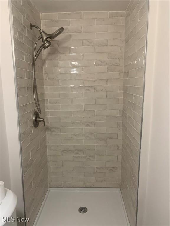 bathroom with tiled shower