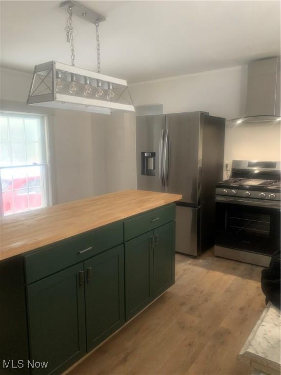 kitchen featuring green cabinetry, butcher block countertops, light wood-type flooring, and appliances with stainless steel finishes