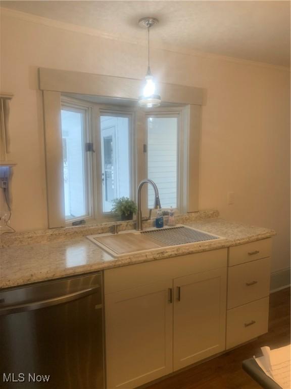 kitchen with hanging light fixtures, light stone counters, sink, white cabinetry, and stainless steel dishwasher