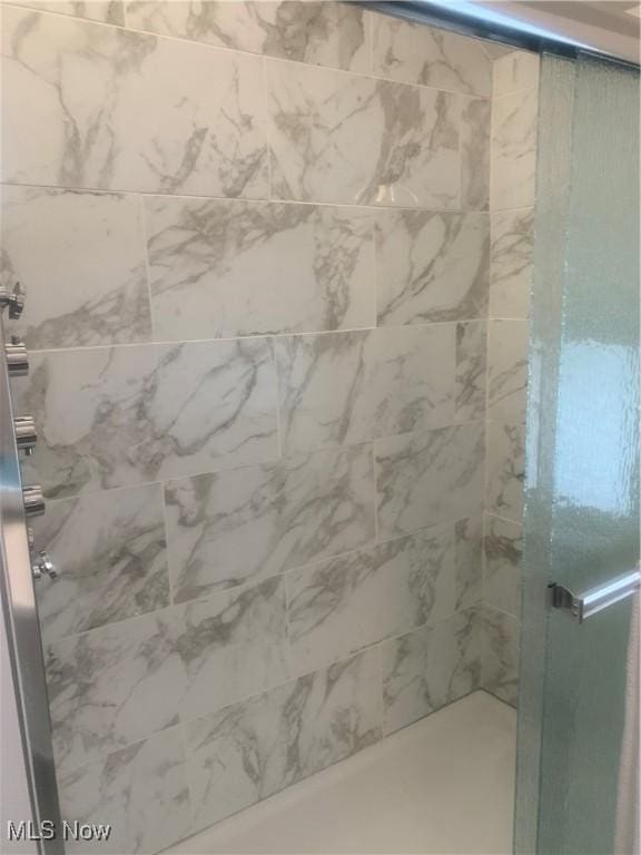 full bath with a tile shower