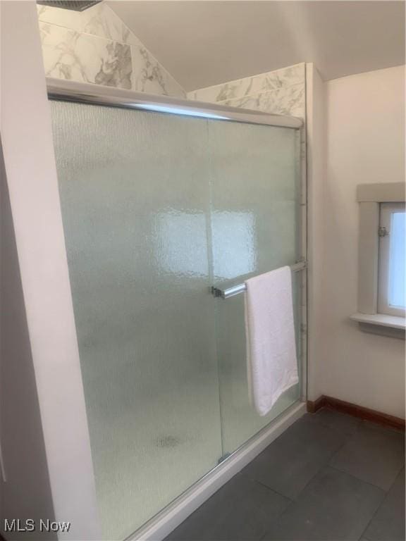 bathroom with lofted ceiling, an enclosed shower, and tile patterned floors