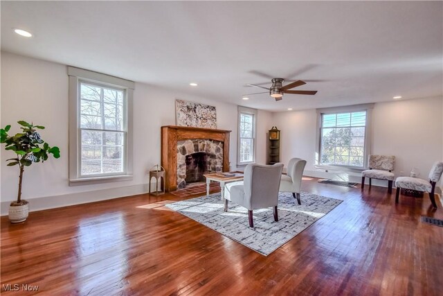 living area with baseboards, ceiling fan, recessed lighting, a fireplace, and wood-type flooring