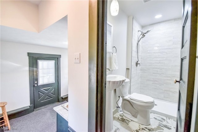 bathroom with visible vents, toilet, and a tile shower