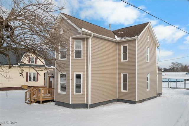 view of snow covered back of property