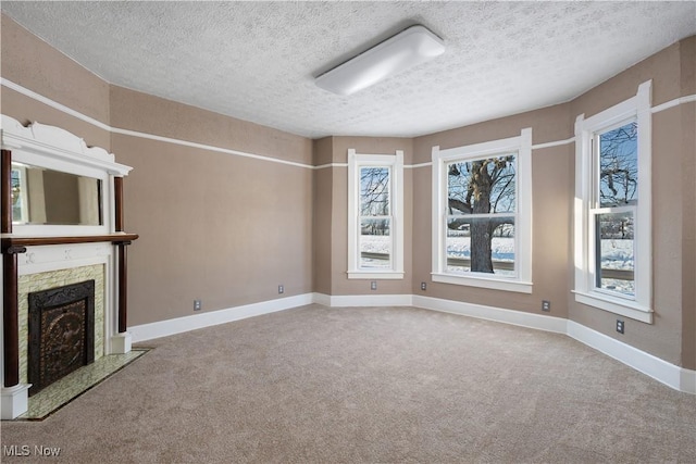 unfurnished living room featuring a textured ceiling, a premium fireplace, and light carpet