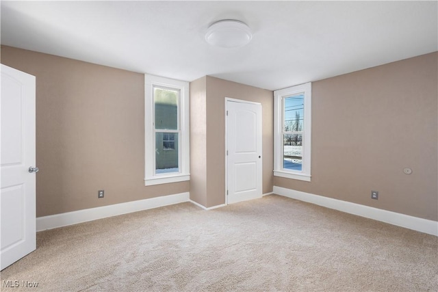 spare room featuring light colored carpet