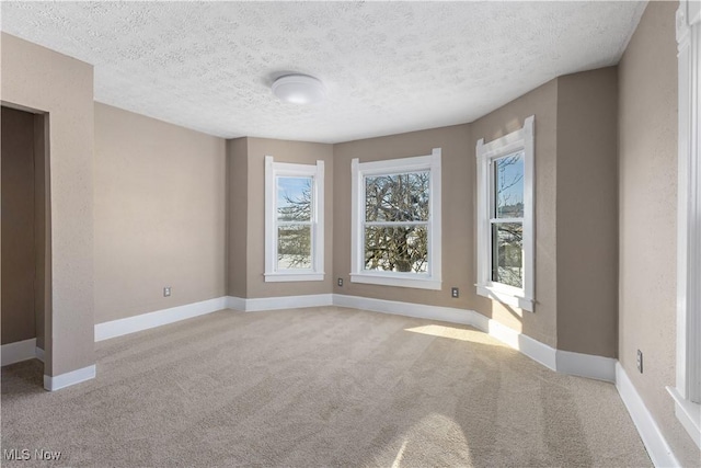 carpeted spare room with a textured ceiling