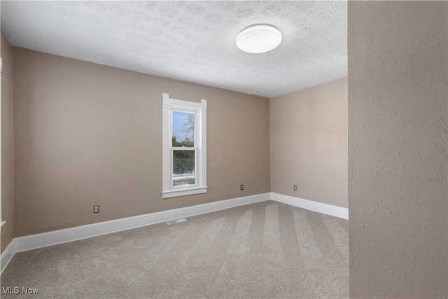 carpeted spare room featuring a textured ceiling