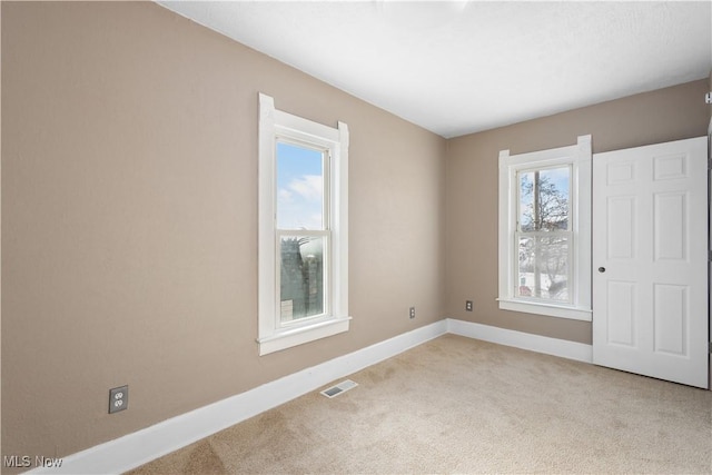 spare room featuring light colored carpet