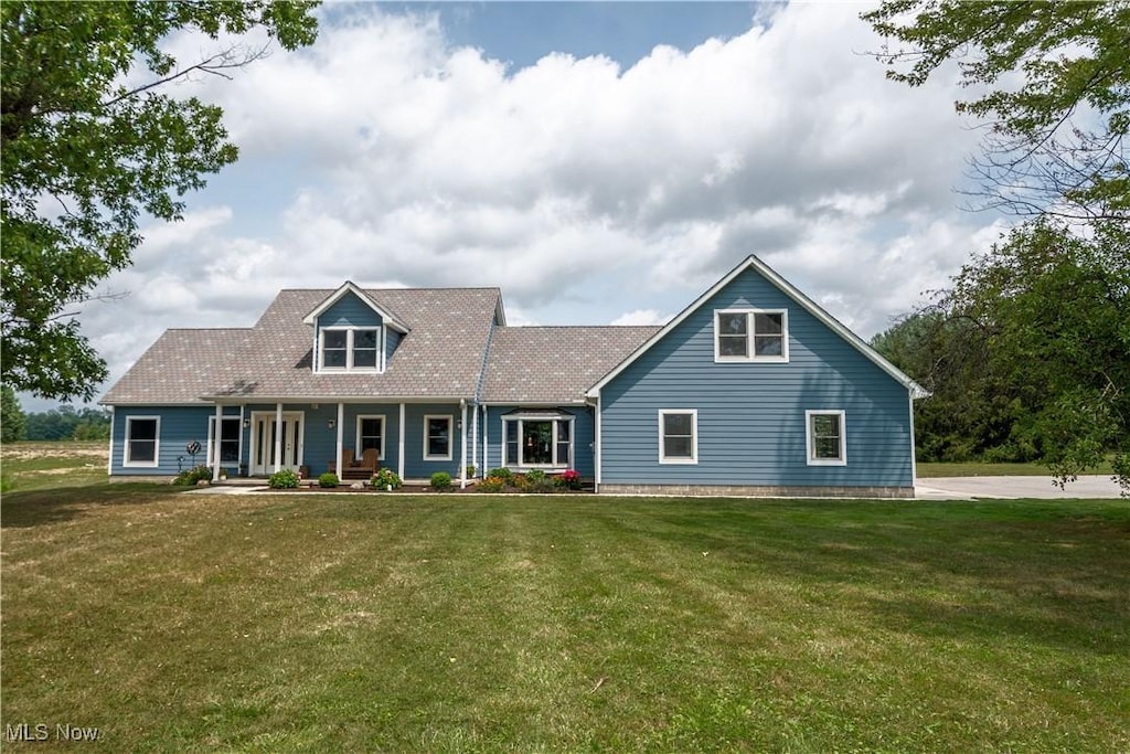 cape cod-style house with a front yard and covered porch