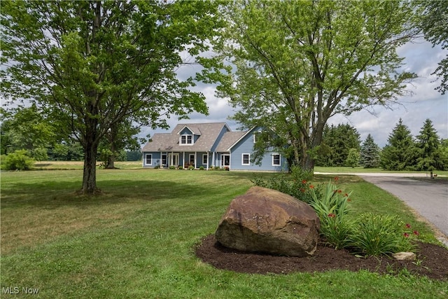 new england style home featuring a front yard