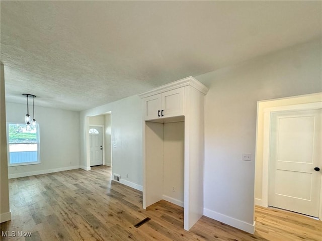 interior space featuring a textured ceiling and light hardwood / wood-style flooring