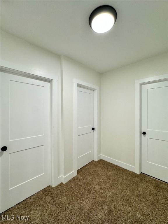 interior space with dark carpet and a closet