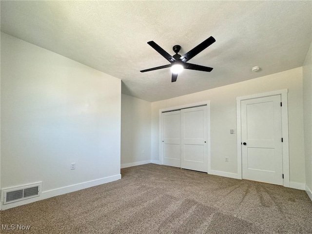 unfurnished bedroom with a textured ceiling, ceiling fan, and carpet floors