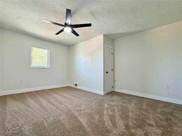 empty room featuring ceiling fan, carpet, and a textured ceiling