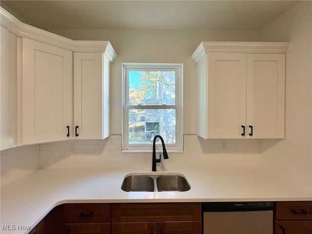 kitchen featuring sink, backsplash, white cabinets, and dishwasher