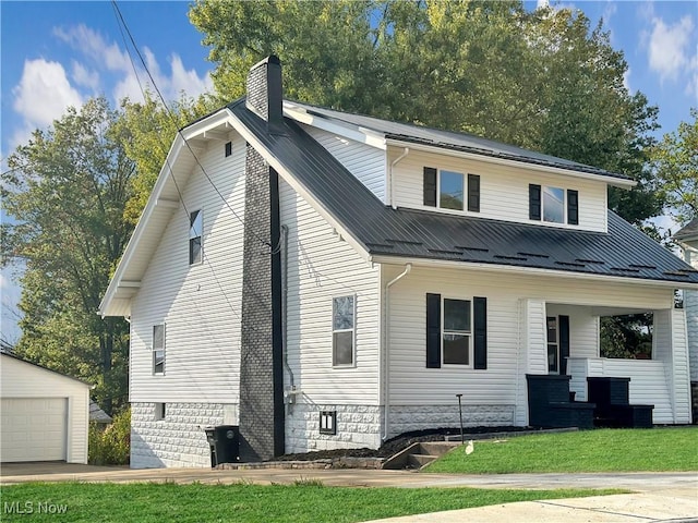 view of front of house featuring a garage, a front yard, an outbuilding, and a porch