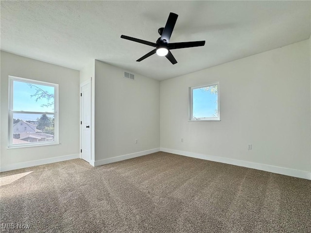 spare room with ceiling fan, carpet floors, and a healthy amount of sunlight