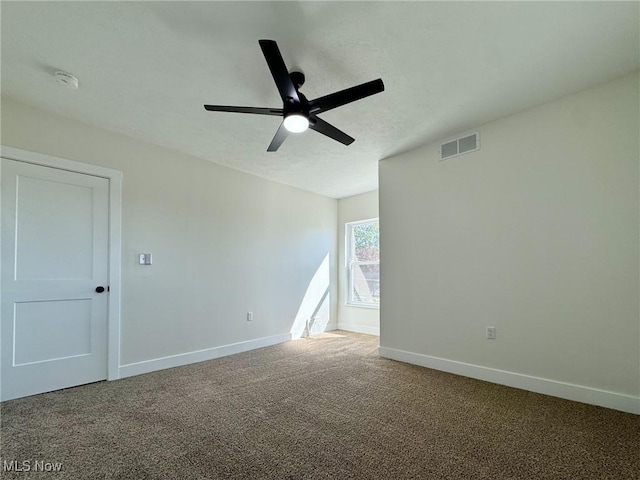 carpeted spare room with ceiling fan