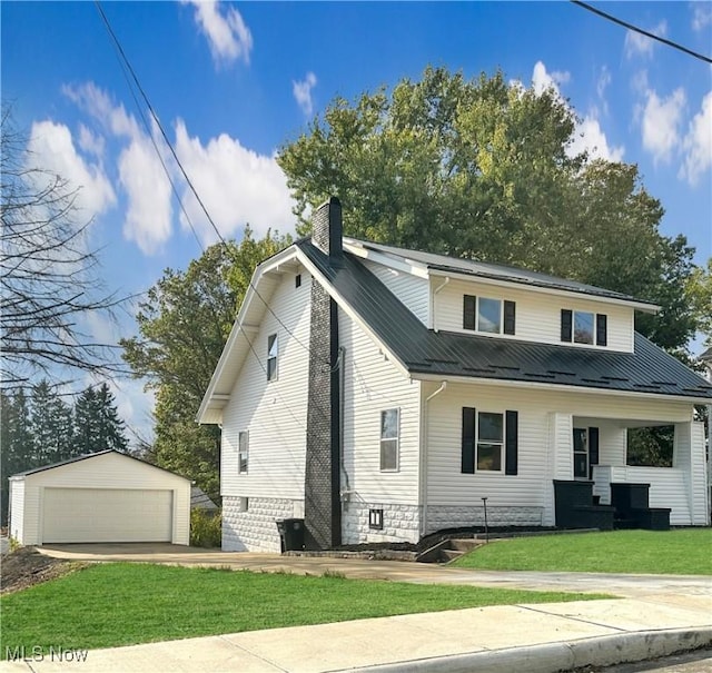 view of front property featuring a garage, a front lawn, and an outbuilding