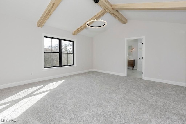 carpeted empty room featuring lofted ceiling with beams and baseboards