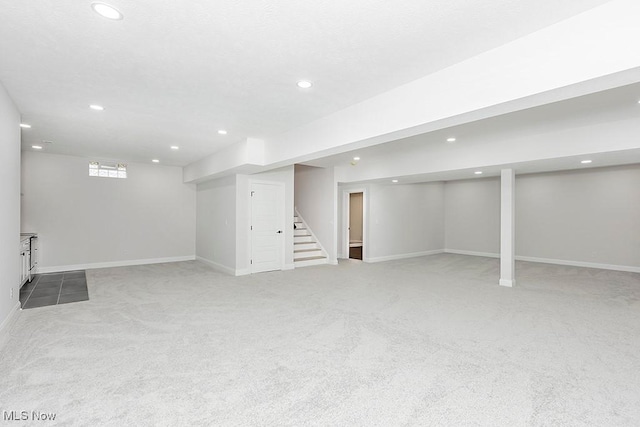 below grade area featuring stairs, baseboards, and recessed lighting