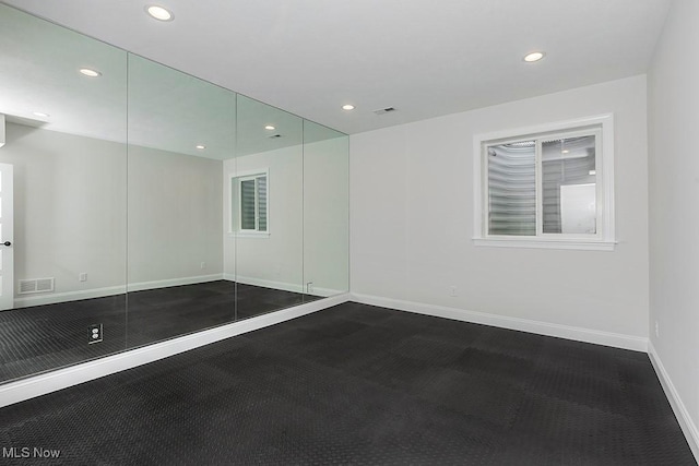 spare room featuring recessed lighting, visible vents, and baseboards