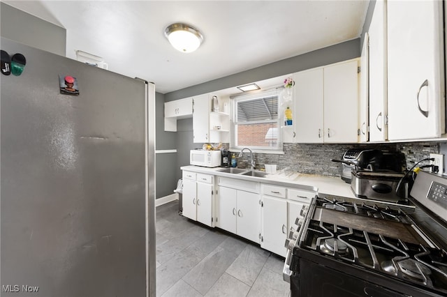 kitchen featuring backsplash, appliances with stainless steel finishes, sink, and white cabinetry