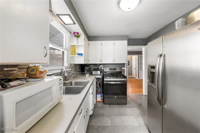 kitchen with sink, white cabinetry, stainless steel appliances, and tasteful backsplash