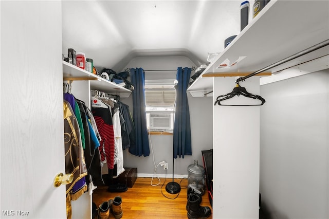 spacious closet with lofted ceiling, wood-type flooring, and cooling unit