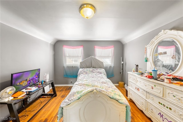 bedroom with vaulted ceiling and light wood-type flooring