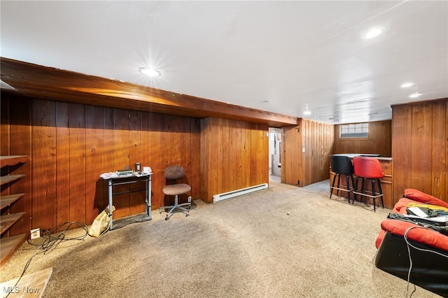 interior space with light colored carpet, a baseboard heating unit, and wooden walls