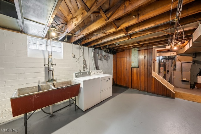 basement with heating unit, washing machine and dryer, sink, and gas water heater