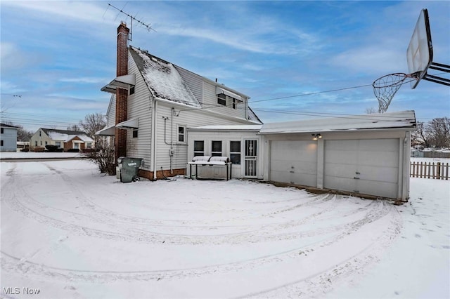 snow covered property with a garage