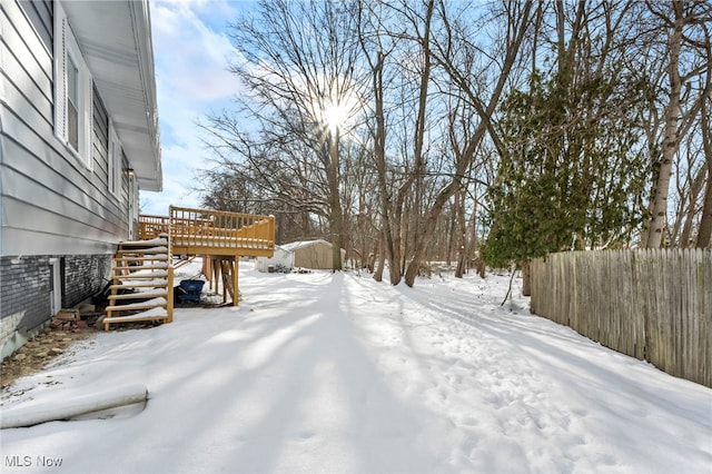 yard layered in snow featuring a wooden deck