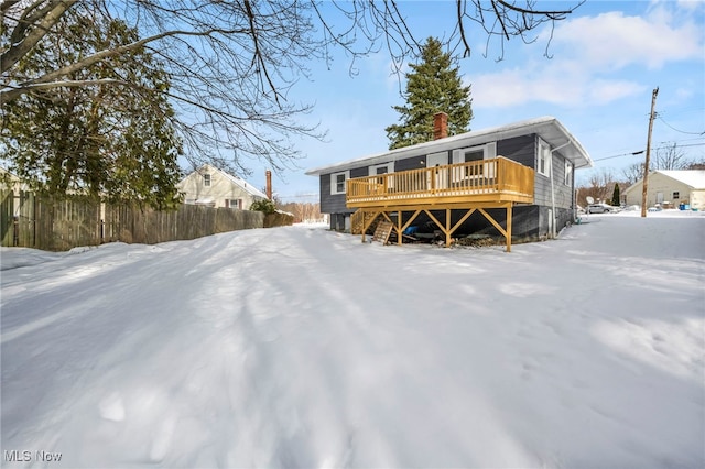 snow covered property with a deck