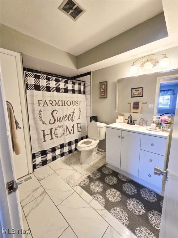 bathroom with vanity, a shower with shower curtain, and toilet