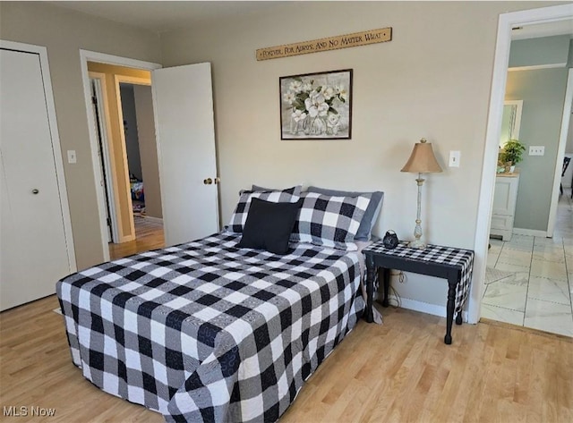 bedroom with light hardwood / wood-style floors and a closet