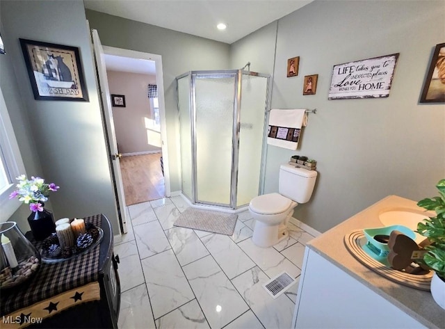 bathroom with vanity, a shower with door, and toilet