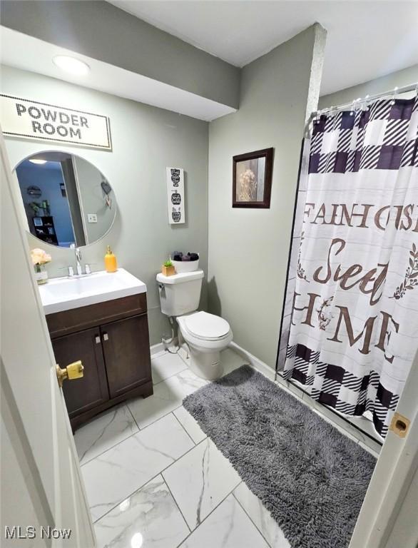 bathroom with walk in shower, vanity, and toilet