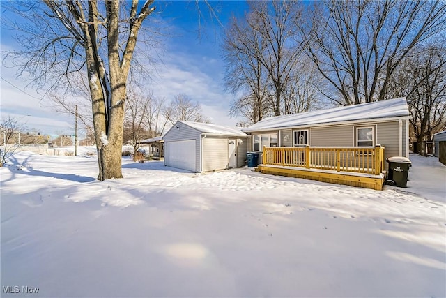 view of front of property featuring a deck, a garage, and an outbuilding