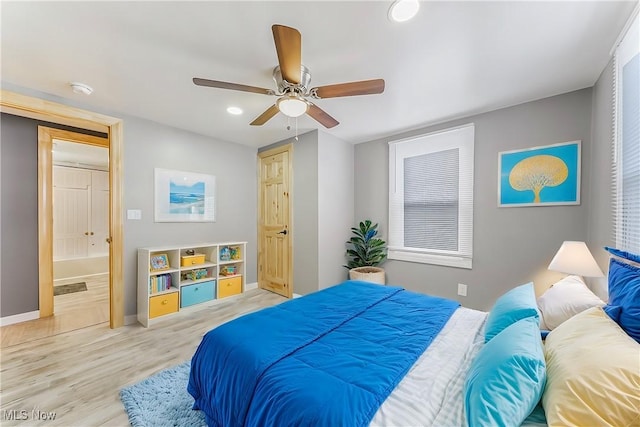 bedroom with light hardwood / wood-style floors and ceiling fan