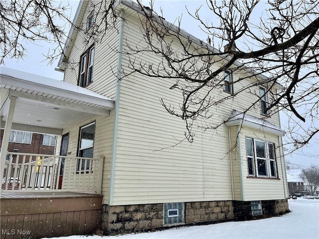 view of snow covered exterior featuring covered porch