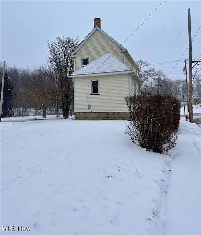 view of snow covered rear of property