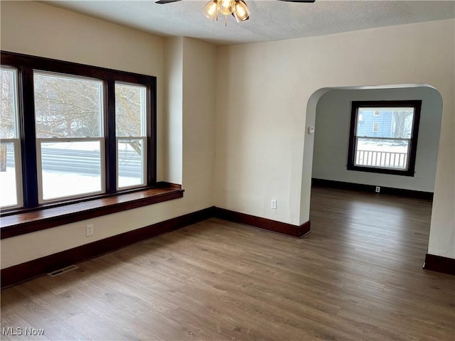 spare room with ceiling fan, wood-type flooring, and a textured ceiling