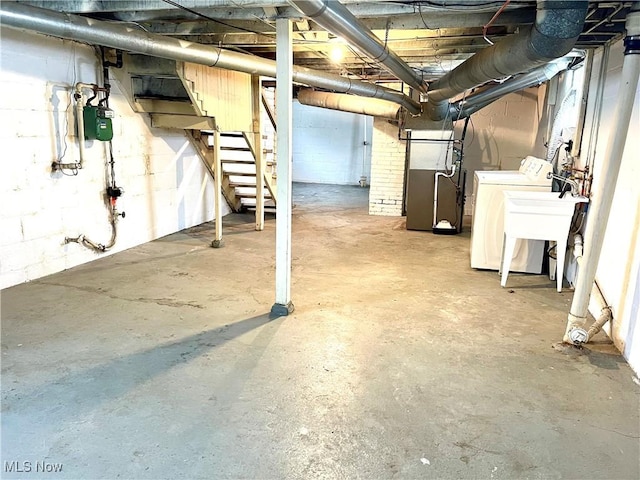 basement featuring heating unit and washer / clothes dryer