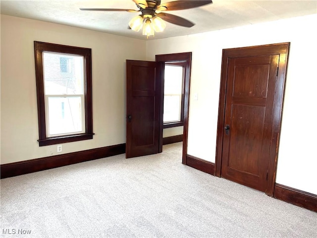 unfurnished bedroom with ceiling fan and light carpet