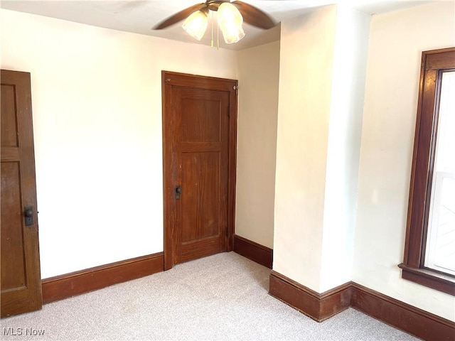 carpeted spare room with ceiling fan