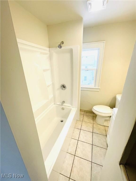 bathroom featuring tile patterned floors, bathtub / shower combination, and toilet