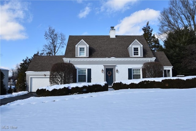 cape cod-style house featuring a garage